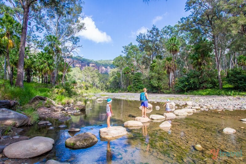 girls crossing rocks across river at Carnarvon Gorge National Park