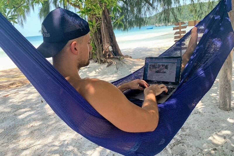 man working on laptop from hammock on Koh Rong Samloem, Cambodia