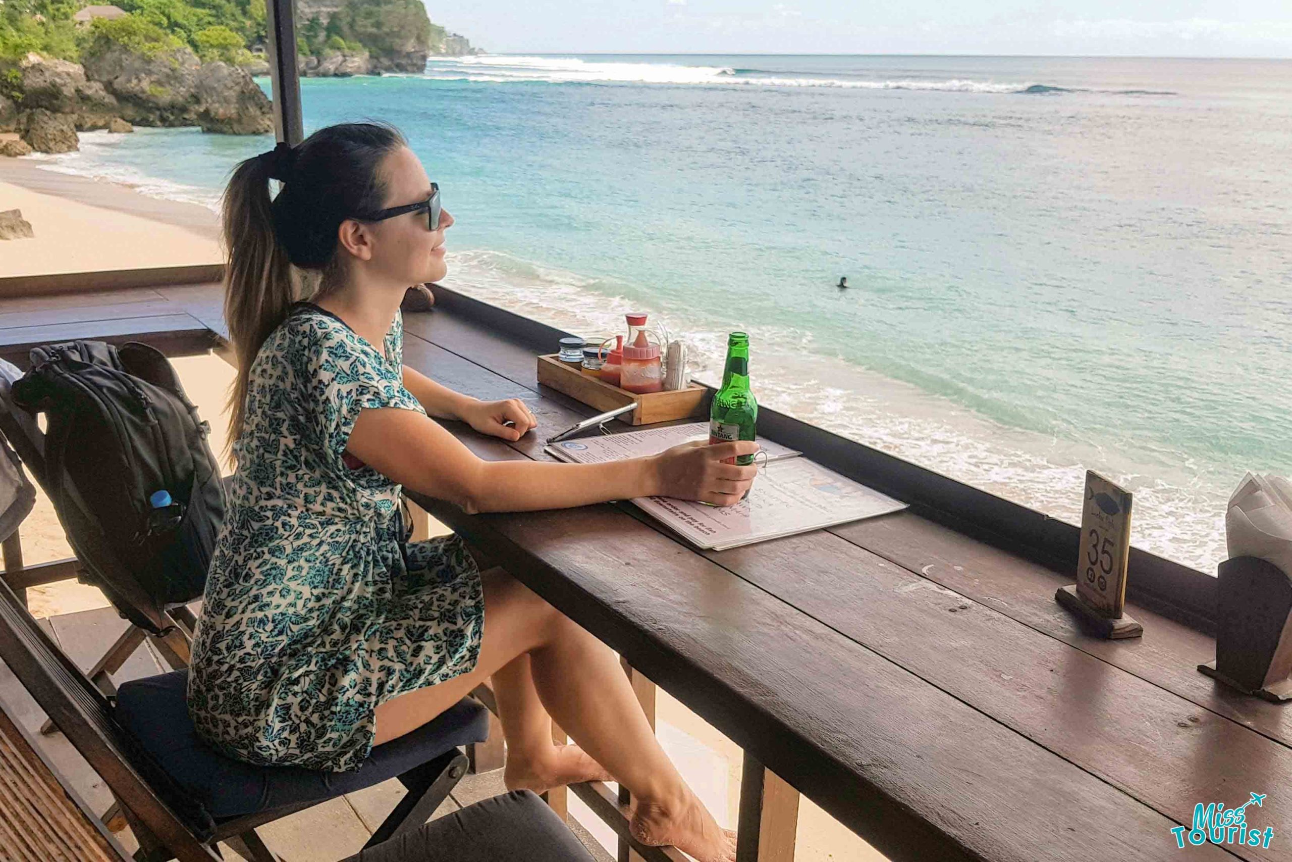 a person sitting at a table on a beach