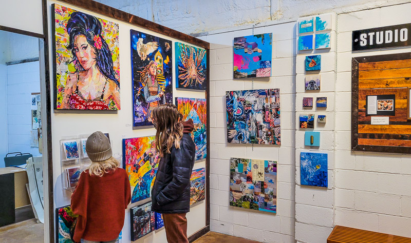 young girls looking at art and painting of amy winehouse. Foundation studios Asheville