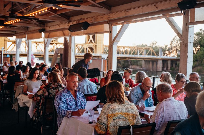 group sitting at waterfront restaurant