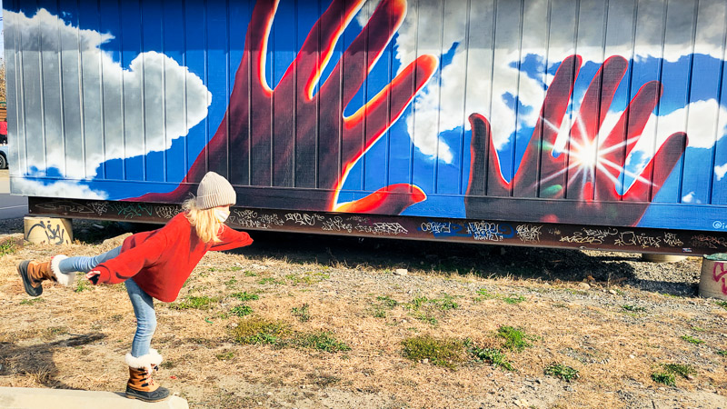 Girl posing in front of mural asheville