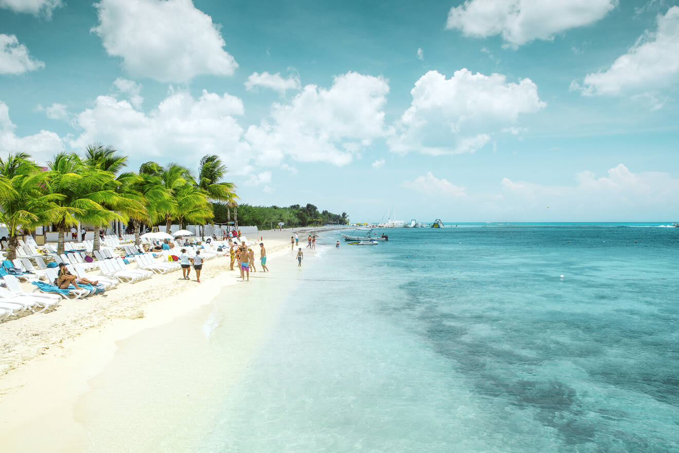 a group of people walking along a beach next to the ocean