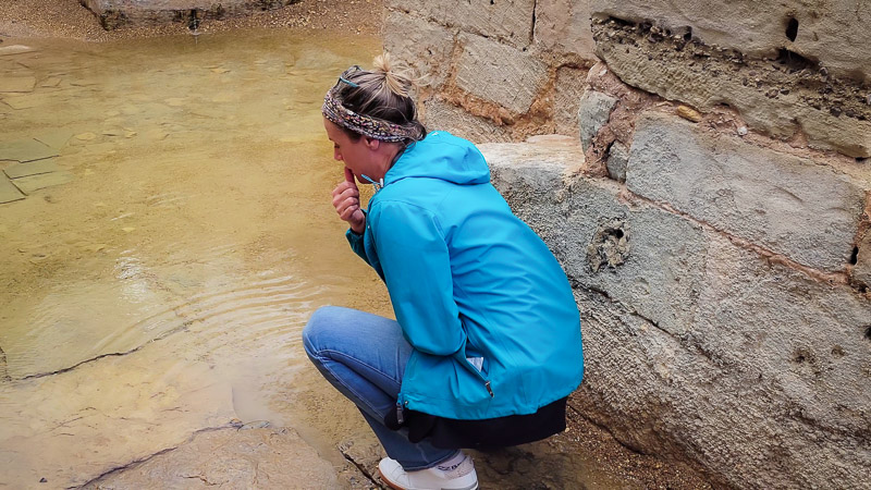 woman touching the water at Jesus baptism pool