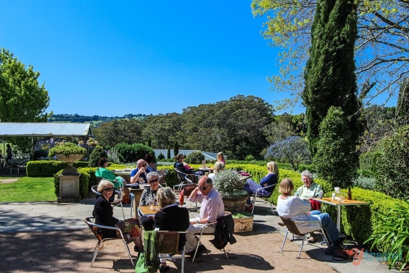 A group of people sitting at tables at the pub garden