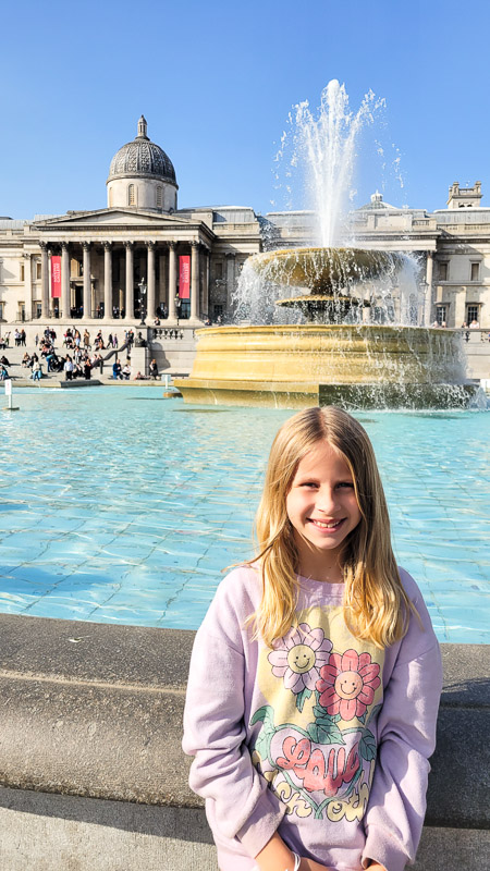 girl standing in front of a water fountain