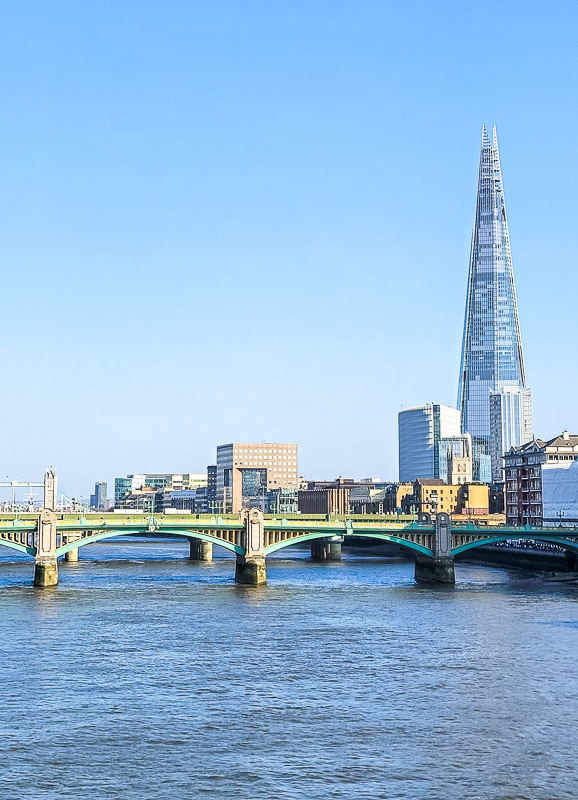 A bridge over water with a city in the background