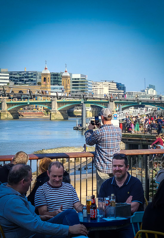 man taking photo of river thames