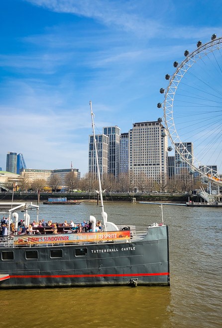 pub boat on river thames with london eye in the backgroun