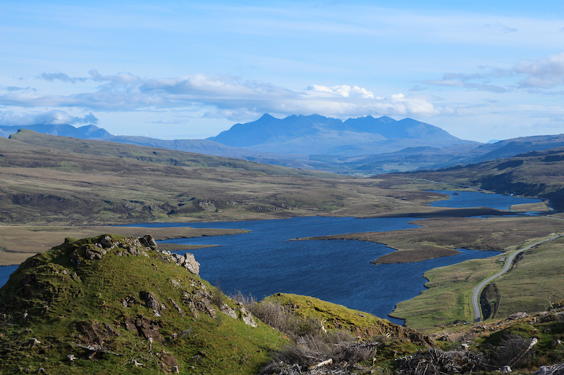 jagged mountain ranges with a lake in the foreground on the Isle of Skye UK