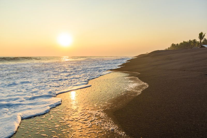 sunset on black sand beach guatemala