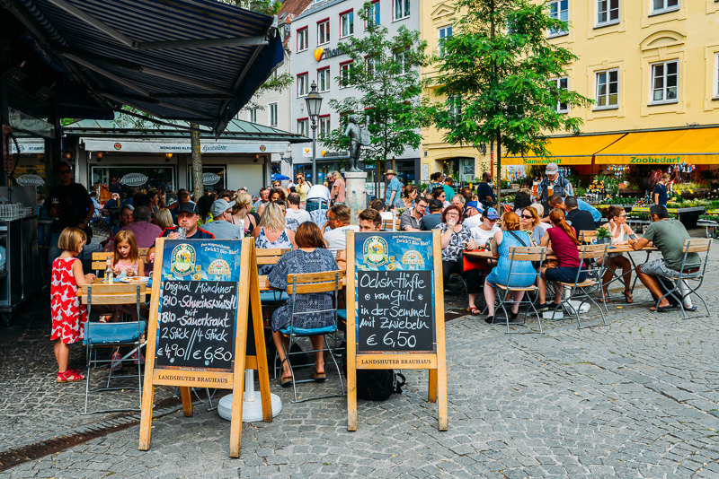 Locals and tourists enjoy beer and food at an open air beer garden in Viktualienmarkt in the historic centre of Munich, Germany