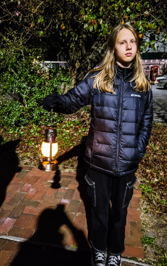 a girl holding a lantern outside