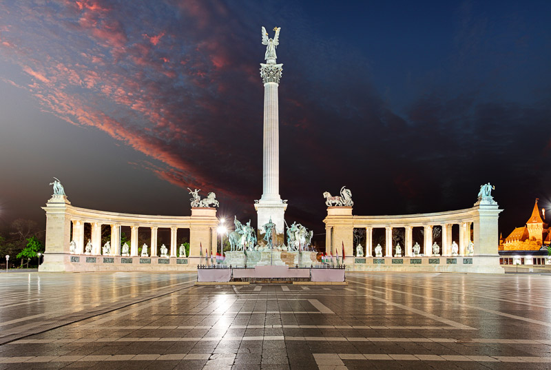 monuments and towers of heroes square lit up at night 