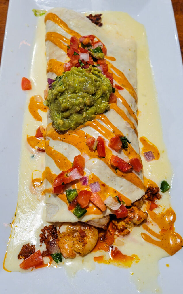 shrimp burrito with cheese sauce on a plate