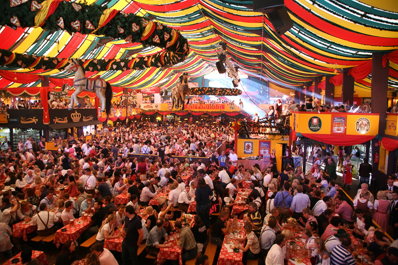 hundreds of people sitting at tables inside Oktoberfest beer hall munich