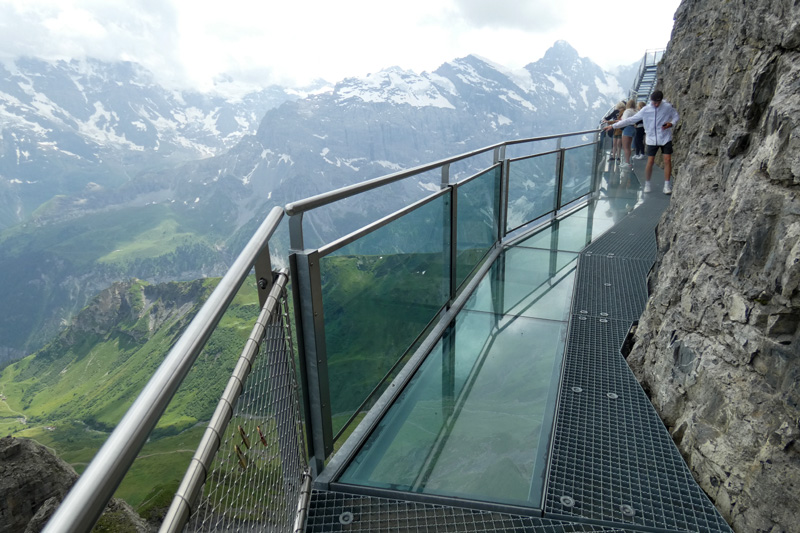 boy walking on a glass path on the edge of the cliff