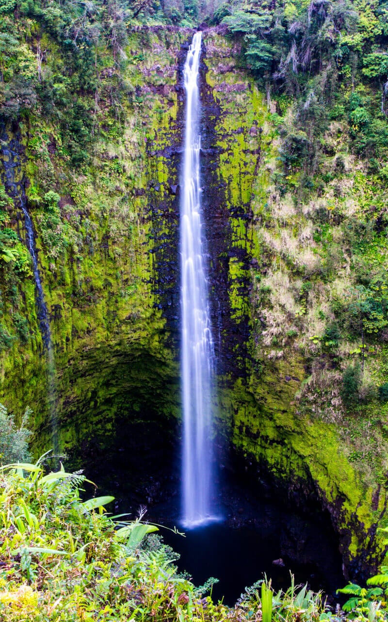 tall waterfall surrounded by lush forest