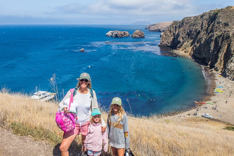 caz and girls posing to camera with beach behind them