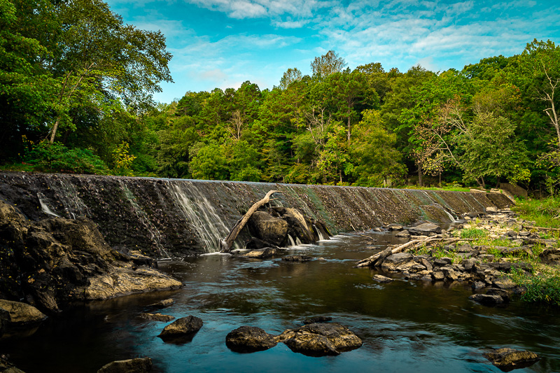 Water cascades over the dam at West Point on the Eno duing a warm summer day. The area is a popular feature of the Eno River State Park in Durham County.