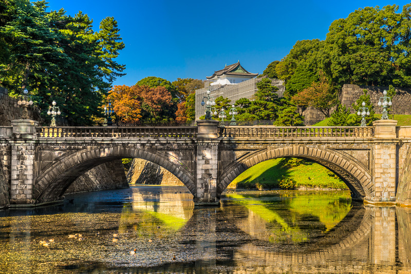 brick double arched bridge with view of imperial palace in background and many trees surrounding it