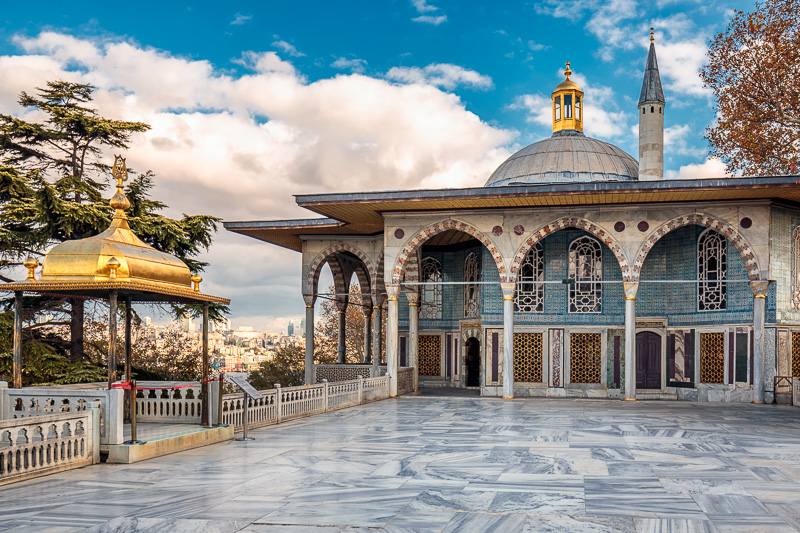 tiled courtyard and building with arched walkways of the topkapi palace