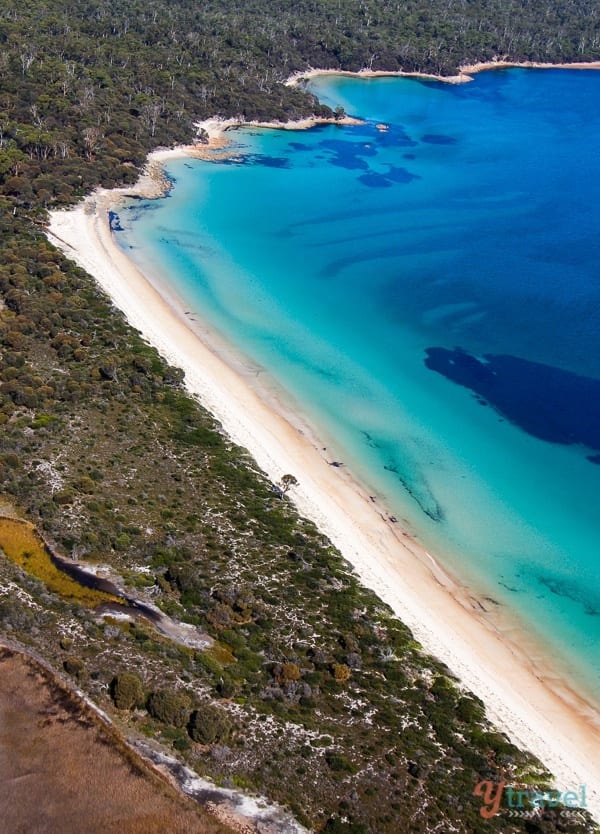 aerial view of the brilliant blue waters and white sand of Hazards Beach in Tasmania, Australia