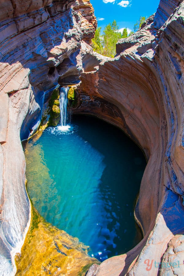 small waterfall falling into pool of water Hamersley Gorge