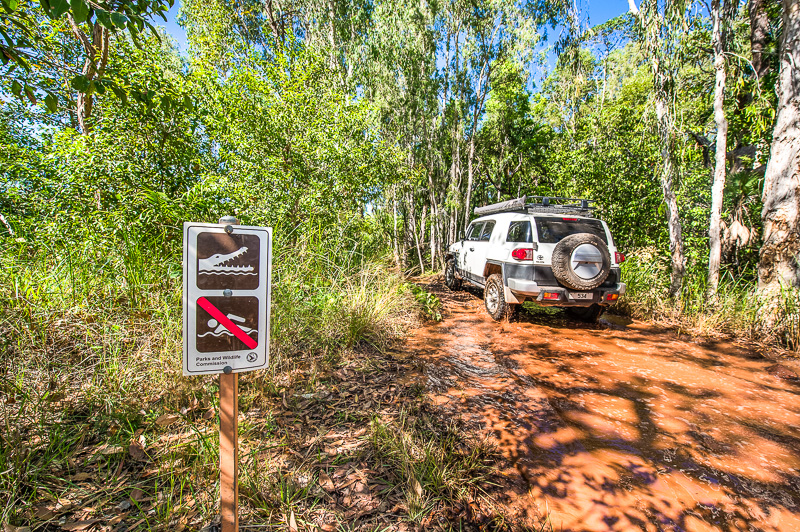 A four-wheel drive driving through a river crossing.