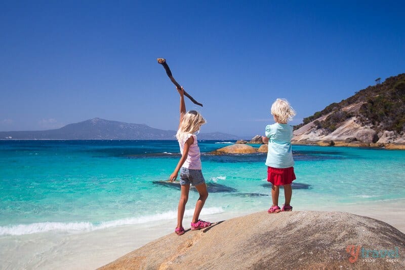 young girls playing on rocks on the beach 