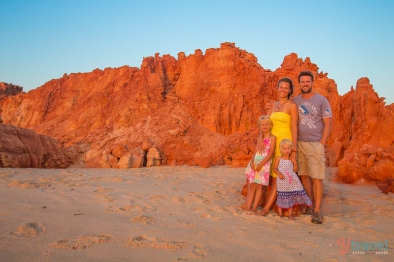 family posing for camera in front of red cliffs on beach at Cape Leveque,