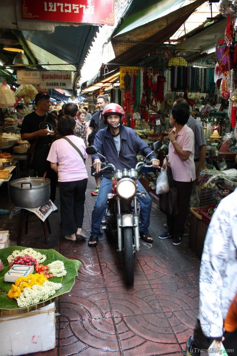 motorbike going through busy Chinatown Bangkok food stall