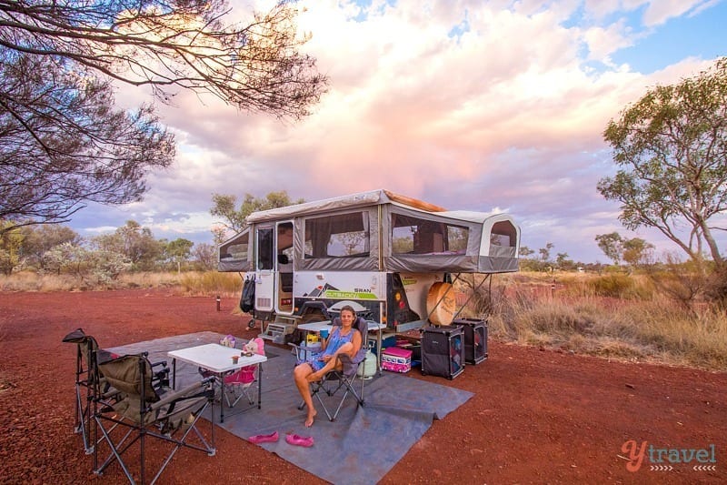 people sitting outside next to a caravan