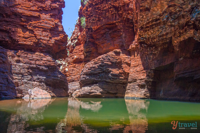 pool of water surrounded by red cliffs