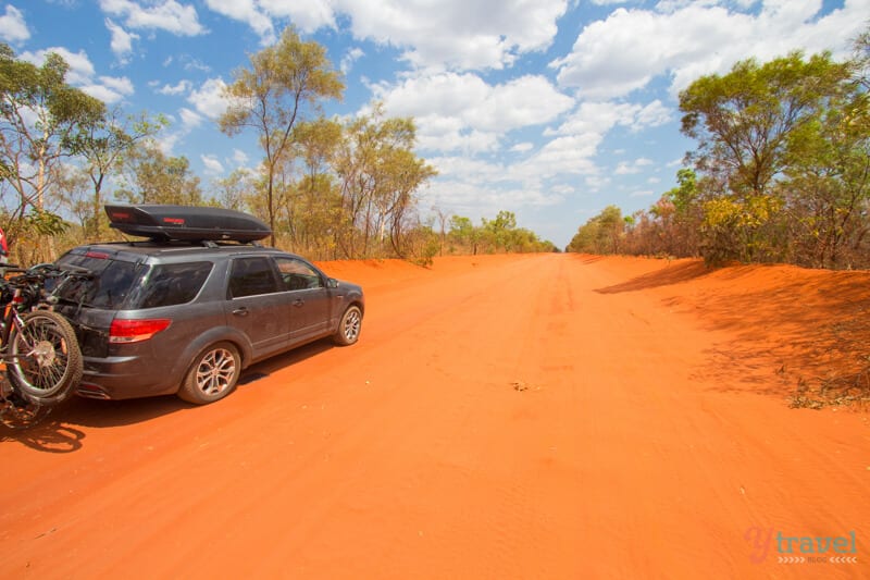 car on red sandy road 