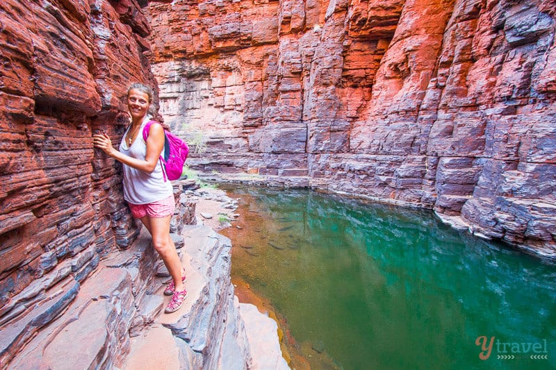 woman on narrow rock ledge clinging to gorge wall