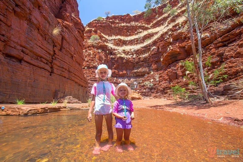 children standing in water in a canyon