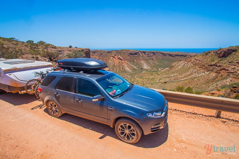 car towing caravan on red road at Charles Knife Canyon