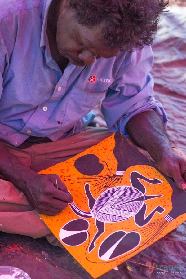 Aboriginal Artist painting an animal