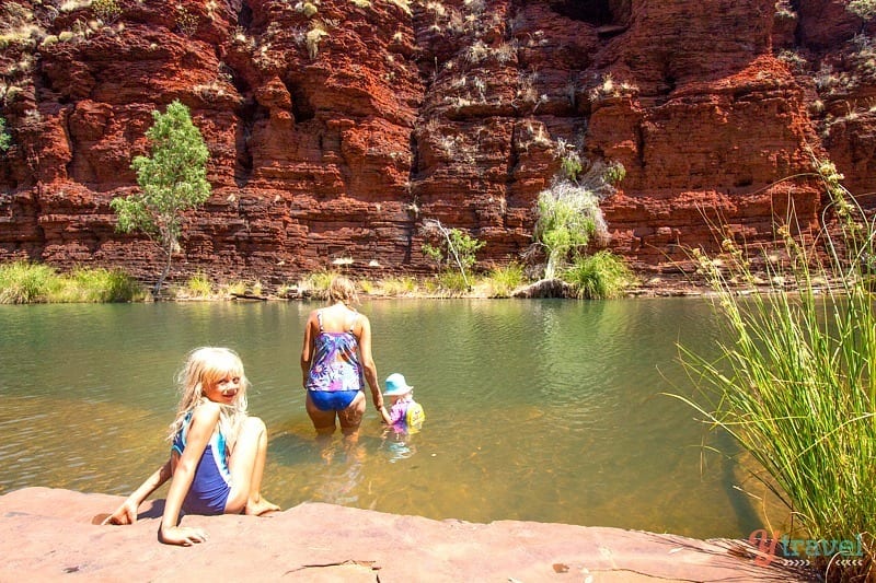 people swimming in water in a canyon