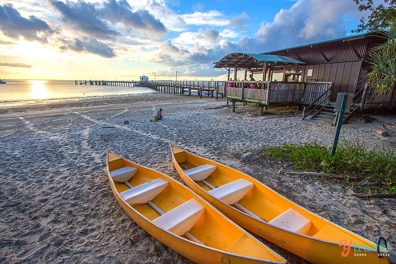 two orange kayaks on the sand out the front of The Jetty Hut on Kingfisher Bay Resort 