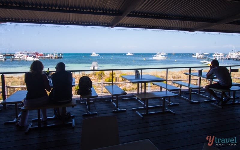 people sitting on tables on a balcony