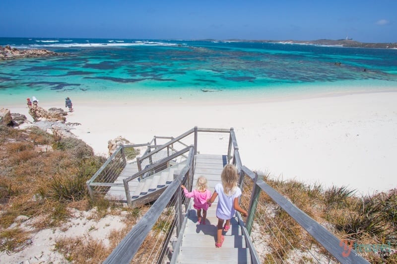 girls walking down wooden stairs leading onto the beach