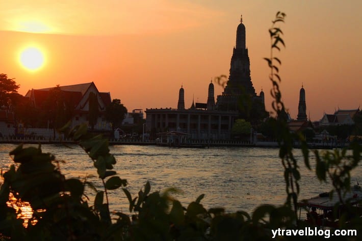 temple sillohuette on banks of river at sunset