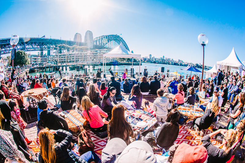 people on Sydney HArbour with views of the  bridge enjoying the aroma festival