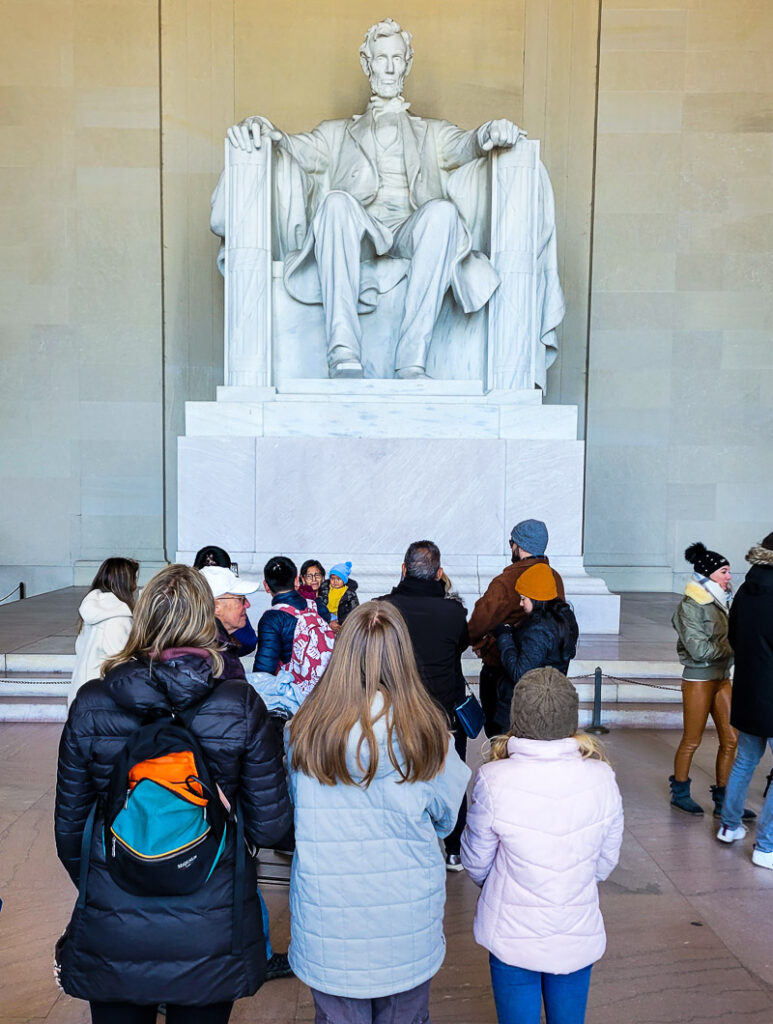 Mom and daughters looking up at monument of Abraham Lincoln