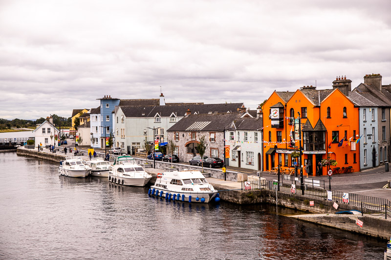 Building and boats sit along the edge of a River in Ireland