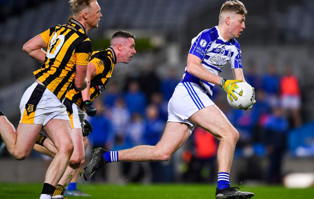 Men playing Gaelic Football and running with a round ball