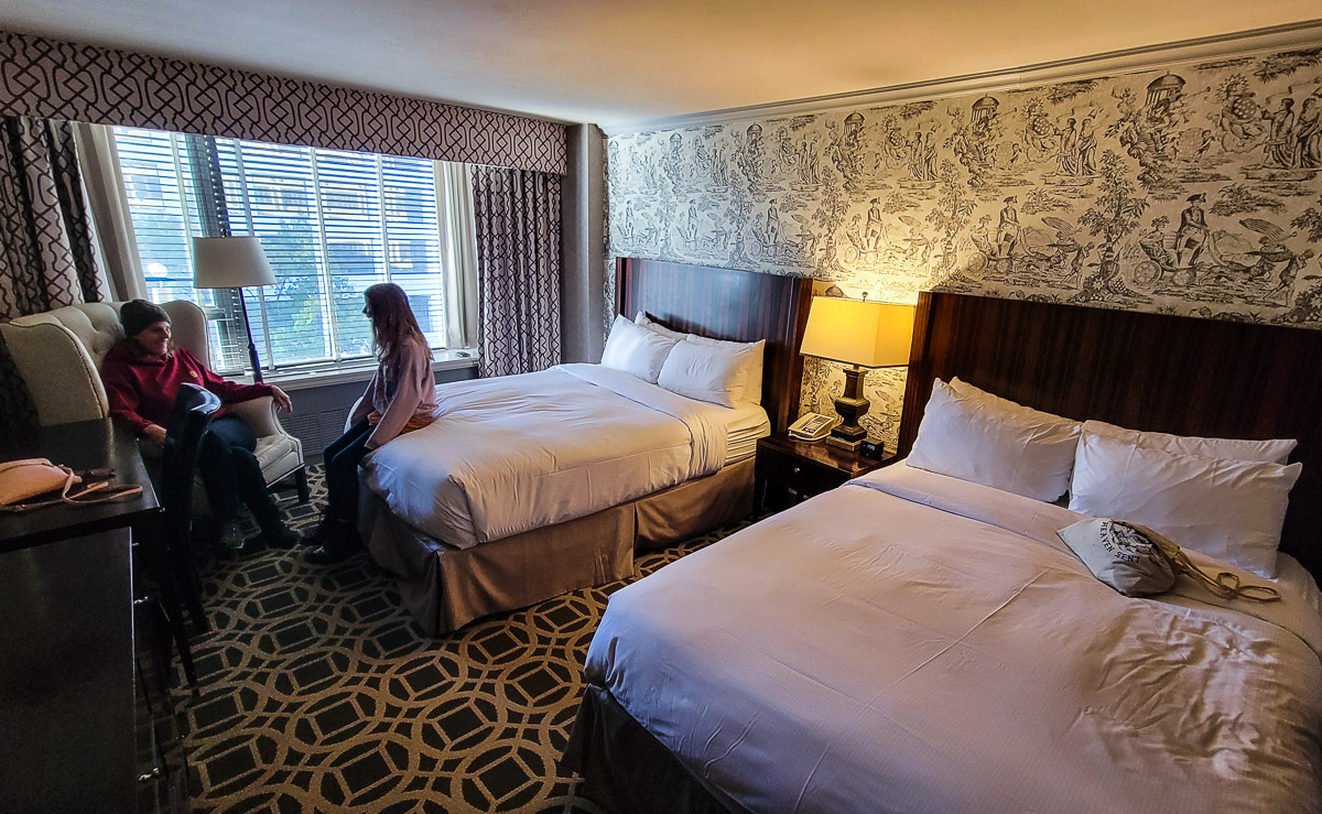 girl sitting on bed in hotel room