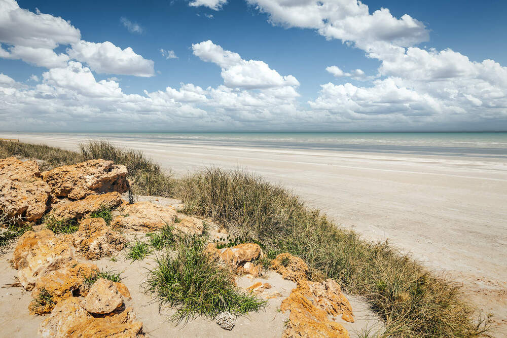 rocky headland and beach with no one on it at Port Hedland